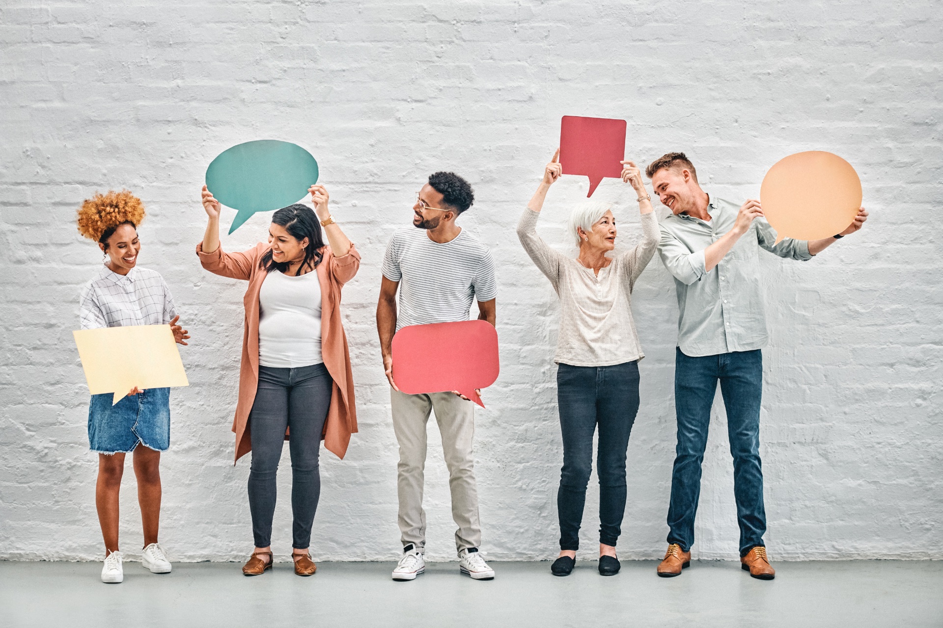 Group of people holding speech bubbles, representing the diversity of career situations supported by the coaching pack.